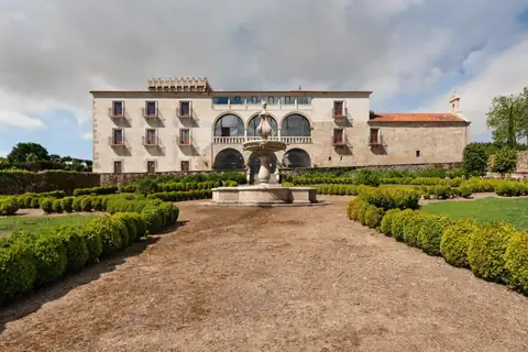 Fachada de piedra del pazo con jardín de boj y fuente central en el Áurea Palacio de Sober