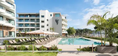 Piscina exterior con sombrillas, palmeras y edificio blanco del Hotel Attica21 Vigo