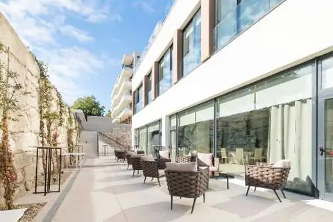 Terraza exterior con sillones junto a la fachada acristalada del Hotel Attica21 Vigo
