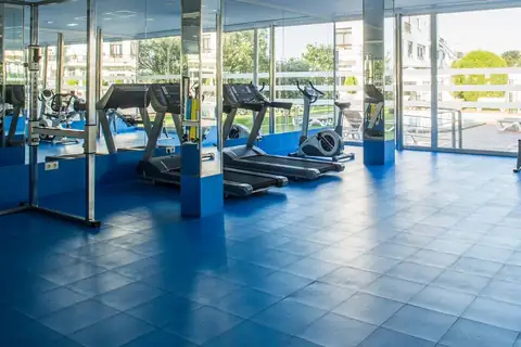 Gimnasio con cintas de correr y ventanales al exterior en el Hotel Nuevo Astur & Spa
