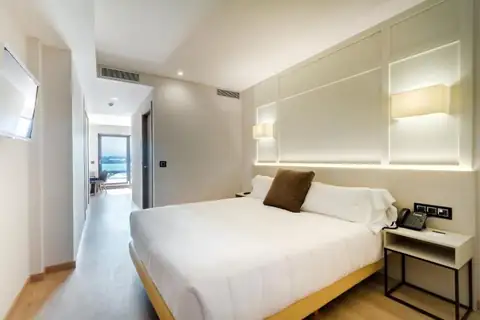 Habitación doble con cama de matrimonio y vistas al mar al fondo en el Playa de Foz Hotel & Spa