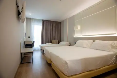 Habitación triple con camas individuales y cortinas en el Playa de Foz Hotel & Spa