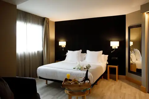 Habitación doble con cabecero oscuro y bandeja de desayuno en el Hotel Plaza A Coruña
