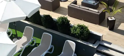 Tumbonas sobre césped artificial junto a la terraza chill out del Hotel Puente de La Toja