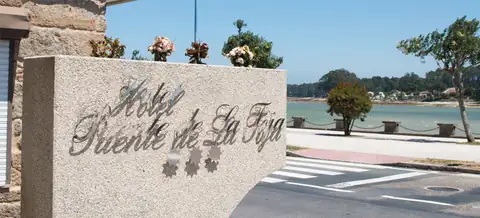 Placa de granito con el nombre del Hotel Puente de La Toja frente al paseo marítimo