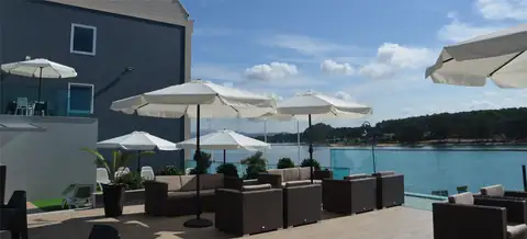 Terraza exterior con sofás y sombrillas junto a la ría en el Hotel Puente de La Toja