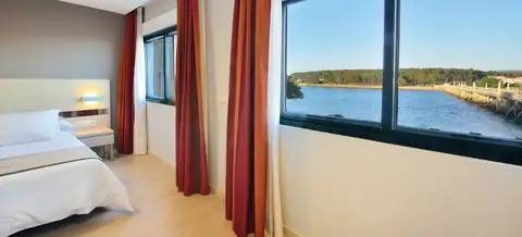Habitación con ventanal y vistas al agua y a la isla en el Hotel Puente de La Toja