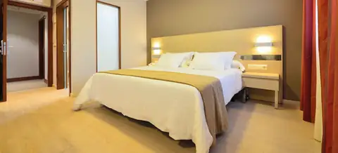 Habitación doble con cama de matrimonio y cabecero iluminado en el Hotel Puente de La Toja