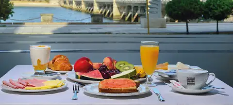Desayuno con zumo, bollería y fruta junto a la ventana del Hotel Puente de La Toja