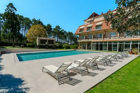 Piscina exterior con hamacas frente al edificio del Hotel Spa Atlántico en San Vicente do Mar