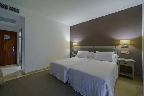 Habitación con dos camas individuales y cabecero tapizado en el Hotel Spa Atlántico