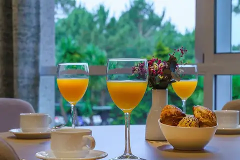 Desayuno con zumo de naranja, café y bollería junto a la ventana del Hotel Spa Atlántico
