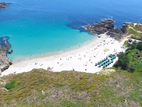 Vista aérea de una playa de arena blanca y aguas turquesas cerca del Hotel Spa Galatea