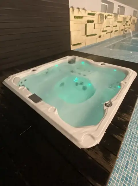 Jacuzzi con luces de colores y borde de madera en el spa del Hotel Spa Meiga do Mar