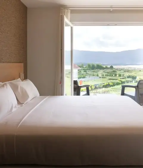Habitación doble con ventana abierta y vistas al campo y los montes en el Hotel Spa Meiga do Mar