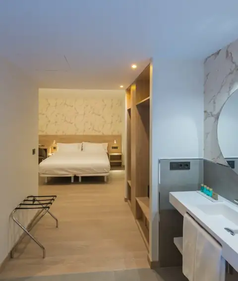 Habitación doble con armario abierto y lavabo moderno a la entrada en el Hotel Spa Meiga do Mar