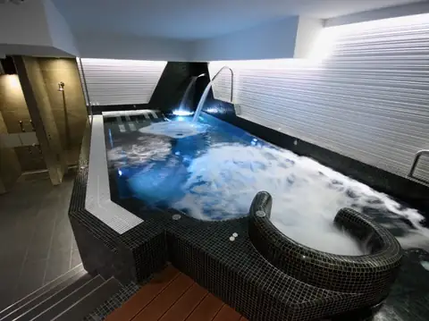 Piscina de hidromasaje iluminada con zona de burbujas en el Hotel Spa Nanín Playa