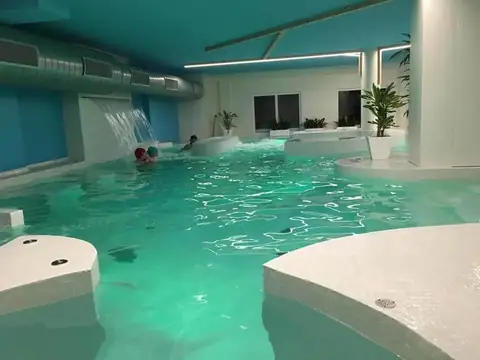 Piscina del spa con luz verde y cascada al fondo en el Hotel Spa Playa Langosteira de Fisterra