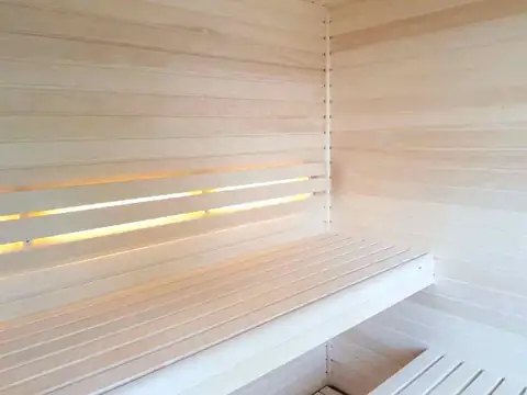 Sauna de madera clara con bancos e iluminación indirecta en el Hotel Spa Playa Langosteira