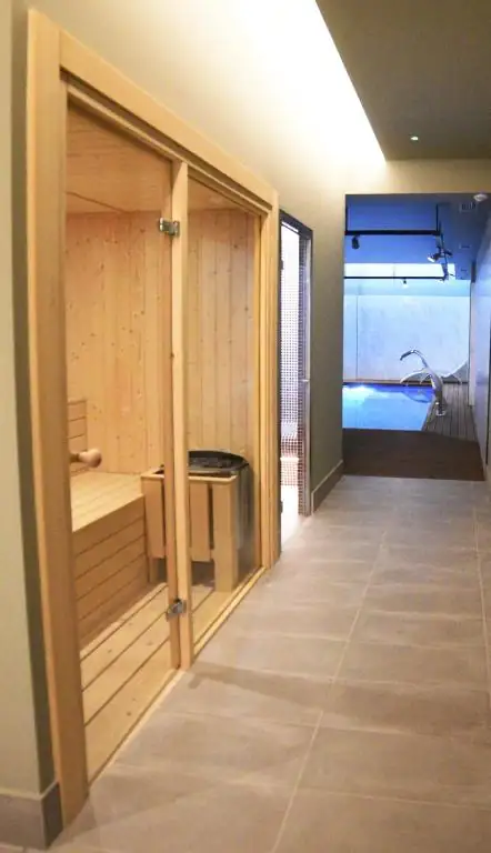 Pasillo del spa con sauna de madera y acceso a la piscina en el IMI Hotel & Spa de Ourense