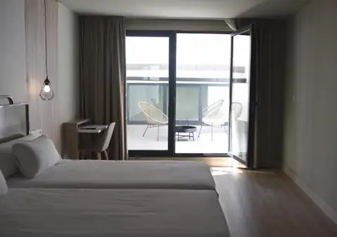 Habitación con acceso a terraza privada con sillas de diseño en el IMI Hotel & Spa de Ourense