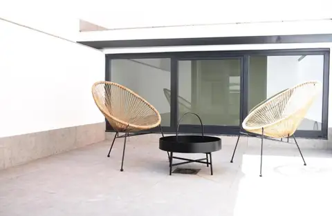 Terraza privada con dos sillones de cuerda y mesa baja en el IMI Hotel & Spa de Ourense