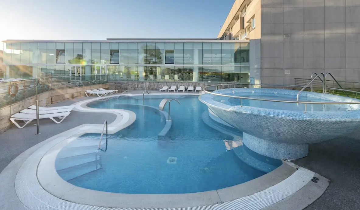 Piscina termal exterior con jacuzzi en un hotel balneario de Galicia