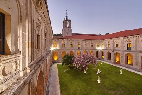 Claustro con jardín y torre del campanario al atardecer en el Monasterio de San Clodio