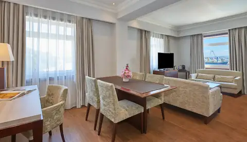 Suite con salón, mesa de comedor y sofá en el NH Collection A Coruña Finisterre
