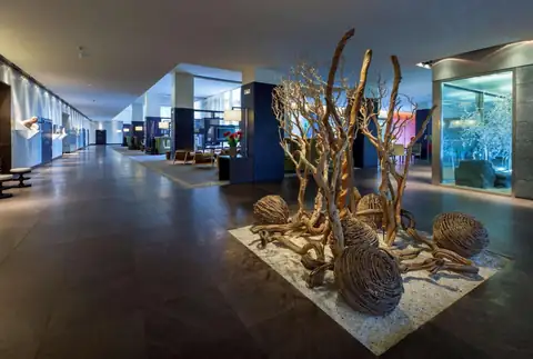 Vestíbulo del NH Collection Santiago con una instalación de ramas y esferas de mimbre