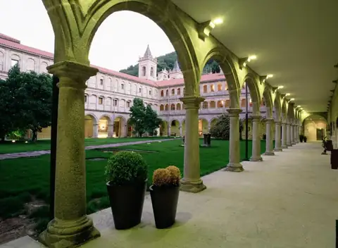 Claustro con arcos de piedra y jardín central del antiguo monasterio, hoy Parador de Santo Estevo