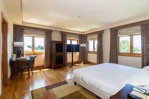Habitación amplia con suelo de madera y varias ventanas en el Pazo Los Escudos de Vigo