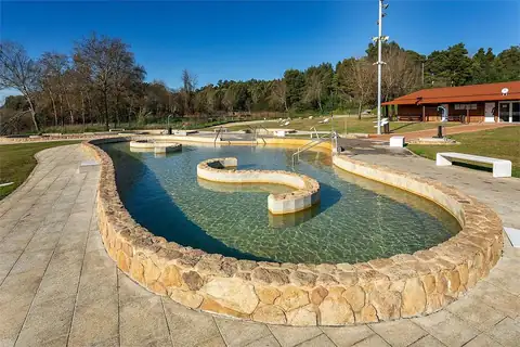 Piscina termal de piedra con isleta central y caseta de vestuarios en las termas de Teáns, Salvaterra de Miño